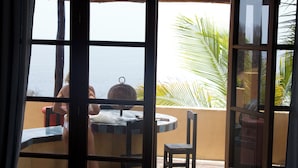 Una habitación con vistas al mar, una mesa redonda y una silla.