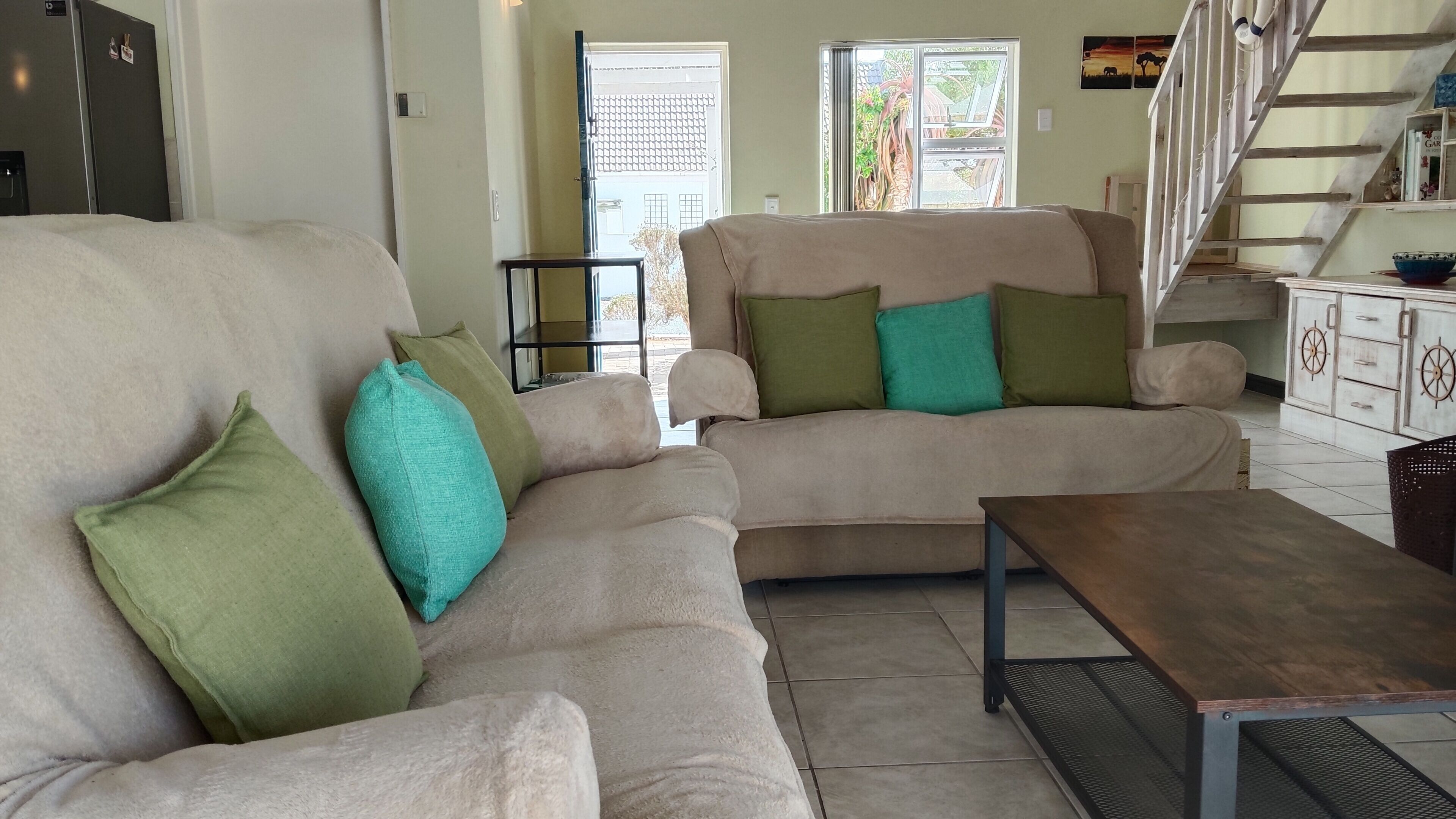 Una sala de estar con un sofá, una mesa de centro y una escalera.