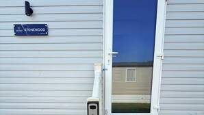 A residential building with a blue door, a security camera, and a sign indicating 'STONEWOOD VICTORY 41-3 BEDROOM.' - 3-bed - Sleeps 6 - Parking - Balcony (Malton)