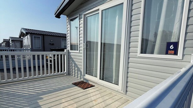 A residential building with a deck, large sliding glass doors, and a mailbox. - 3-bed - Sleeps 6 - Parking - Balcony (Malton)