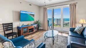 Ein Wohnzimmer mit Fernseher, einer Couch und einem Balkon mit Blick.