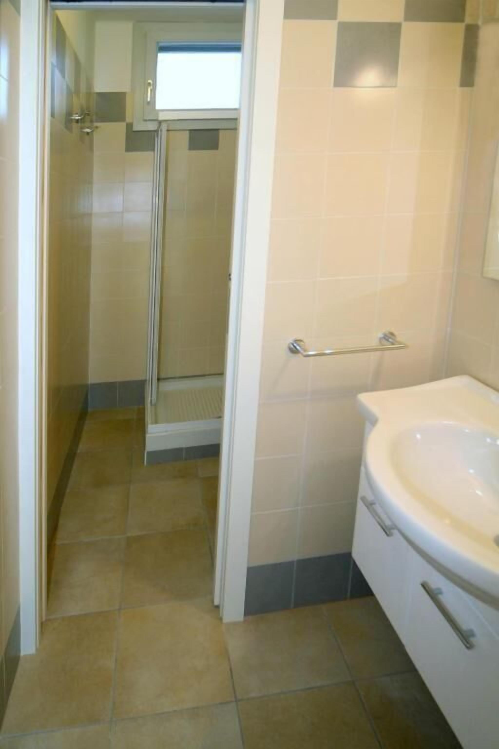 Ein Badezimmer mit Dusche, Toilette und Waschbecken.
