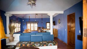 A room with a blue sofa, a wooden bench, a star-shaped ceiling light, and a wooden door. - Villa Xcaanda (San Pedro Pochutla)