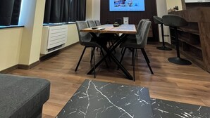 A modern conference room with a large table, chairs, a projector screen, and a wooden accent wall.