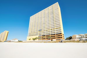 Un hotel modern i alt, amb nombroses galeries, situat a prop d'una platja.