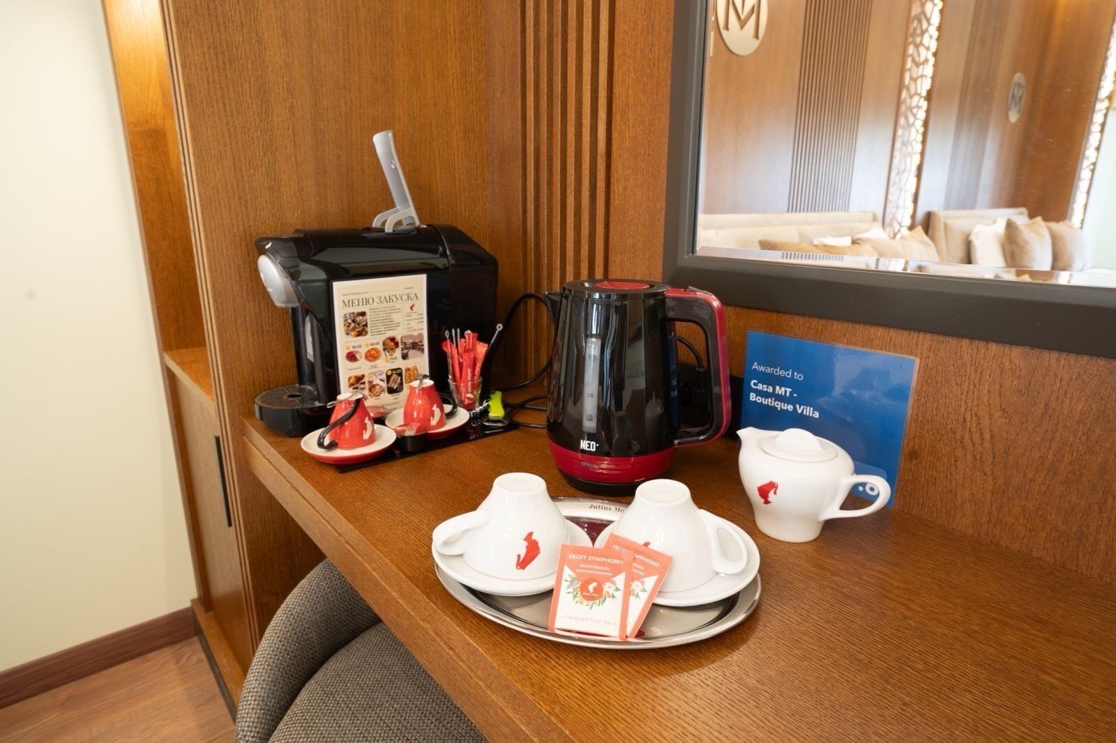 Et hotelreceptionsområde med kaffemaskine, teposer og en menu.