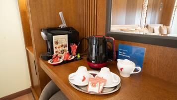 Et hotelreceptionsområde med kaffemaskine, teposer og en menu.