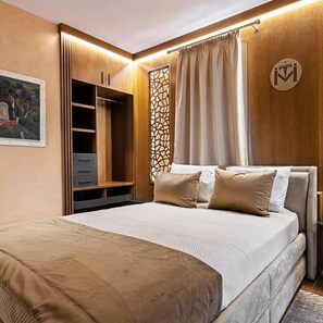 Un dormitorio con cama, armario, biombo decorativo y un logotipo en la pared.