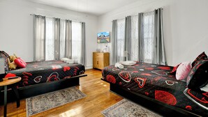 A bedroom with two beds, a ceiling fan, a wooden cabinet, and a painting on the wall. - Spacious 6-bedroom apartment in gorgeous Birmingham with AC, secured parking lot (Birmingham)