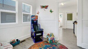 A room with a basketball hoop, colorful butterfly wall decorations, a play area with toys, and a patterned rug. - Spacious 6-bedroom apartment in gorgeous Birmingham with AC, secured parking lot (Birmingham)