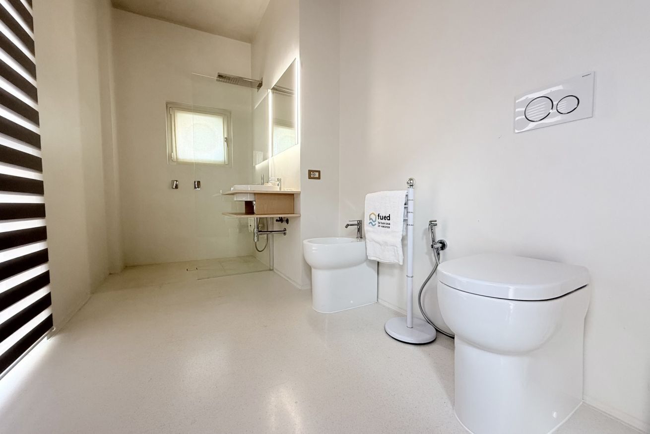 A modern bathroom with a toilet, bidet, and sink.