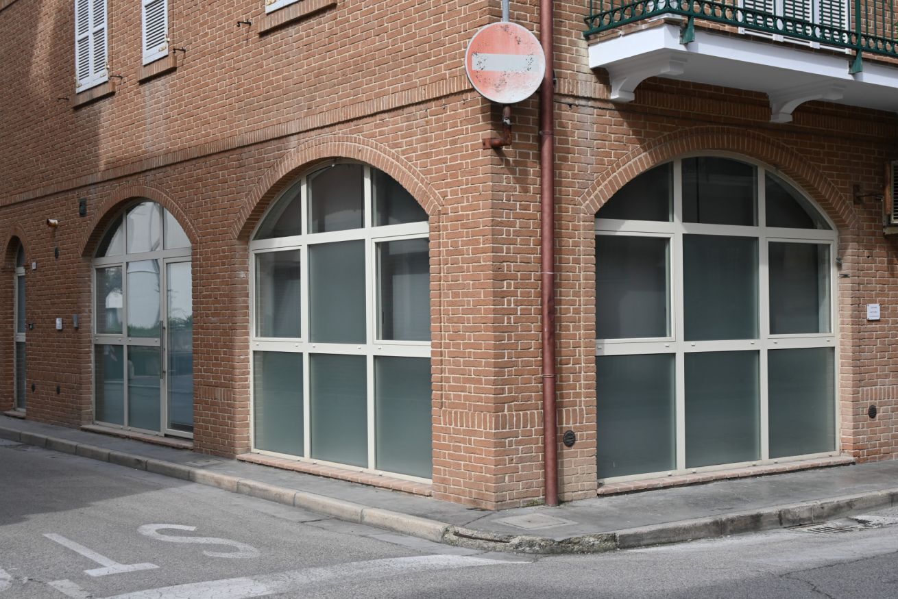 A brick building with large arched windows and a 'no entry' sign.