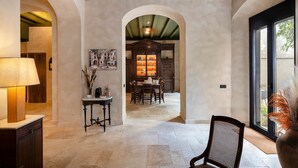 Un intérieur spacieux comprenant un coin repas, une lampe et une vue dégagée sur l’extérieur grâce à une grande fenêtre.