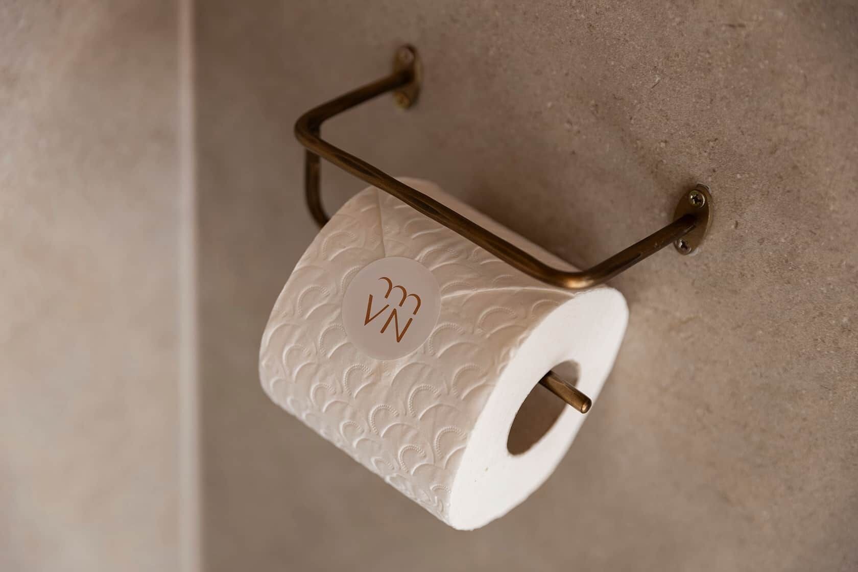 Un rollo de papel higiénico sujeto a la pared con un sujetapapeles metálico.