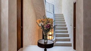 Ein Flur mit einem runden Teppich, einer Vase mit Blumen und einer Treppe.