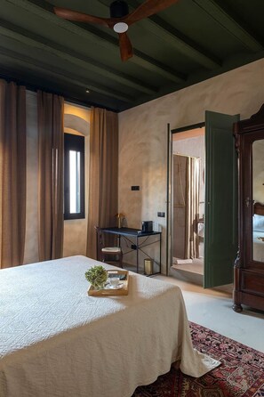 Un dormitorio con cama, escritorio y zona de ducha.