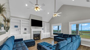 Un amplio salón con un sofá modular grande, chimenea y televisión.