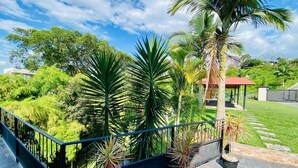 A balcony with a view of a lush garden, a gazebo, and a pathway. - Private Countryside Retreat Jacuzzi & Scenic View (pereira)
