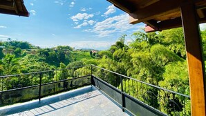 A balcony with a view of a lush green landscape and a clear blue sky. - Private Countryside Retreat Jacuzzi & Scenic View (pereira)