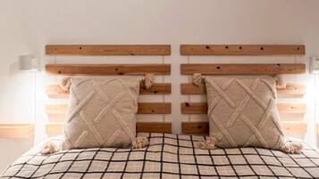 A bed with a checkered bedspread and two pillows with a diamond pattern.