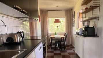 Cocina compacta con estufa, fregadero y comedor.