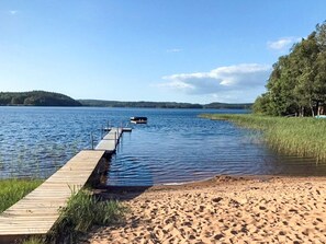 A wooden dock extending into a lake, surrounded by sand and grassy areas. - 5 Person Holiday Home in Holsljunga (Holsljunga)