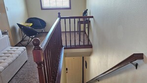 Una escalera con barandilla de madera que lleva a una plataforma.