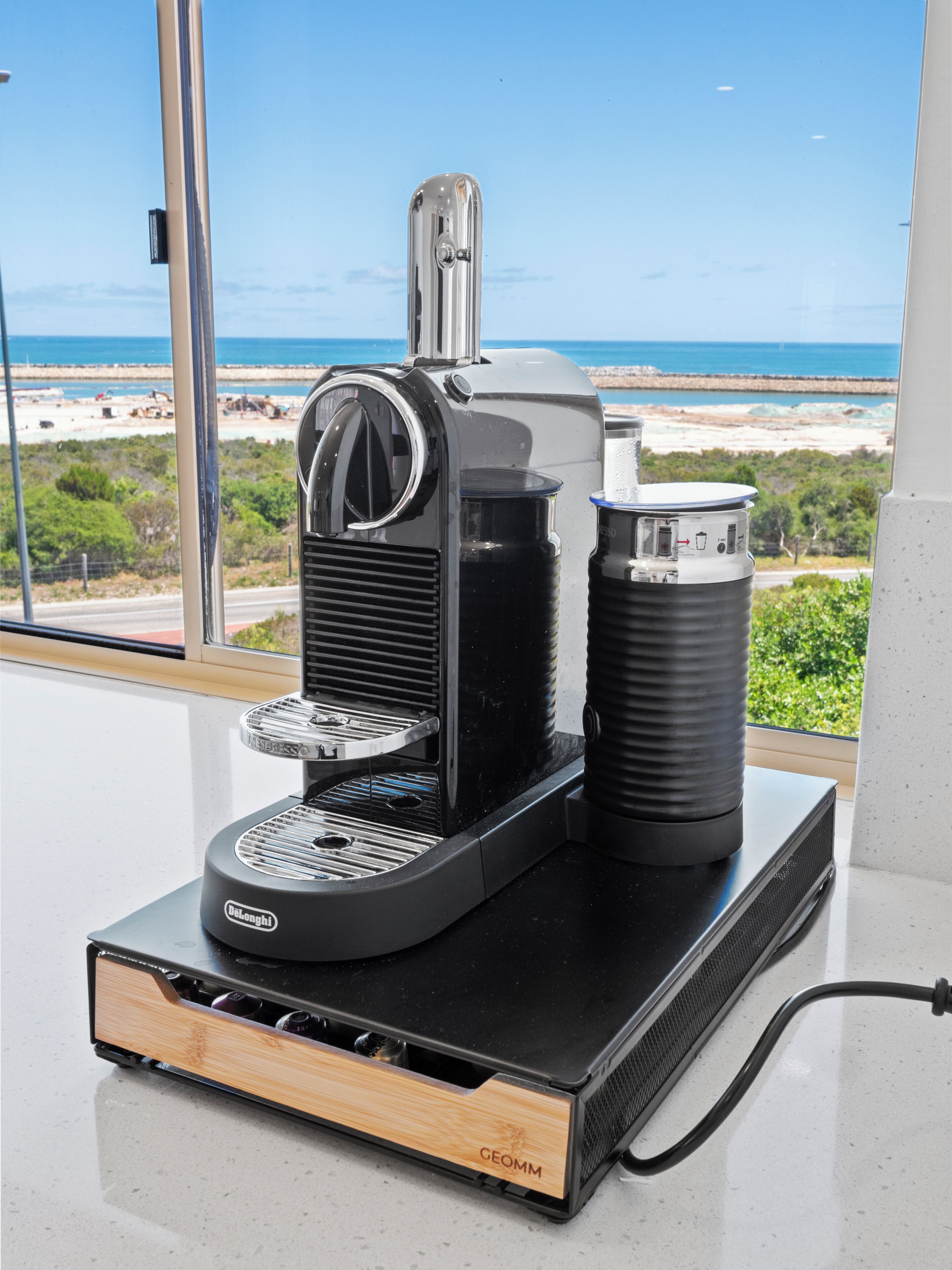 A coffee machine with a water reservoir and a coffee pod holder on a countertop.