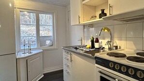 Une cuisine avec une fenêtre, une cuisinière et un évier.