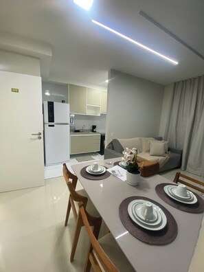 Um apartamento moderno com área de refeições, cozinha e sala de estar.