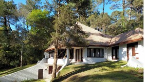 A house with a sloped roof, a porch, and a small staircase leading to the entrance.