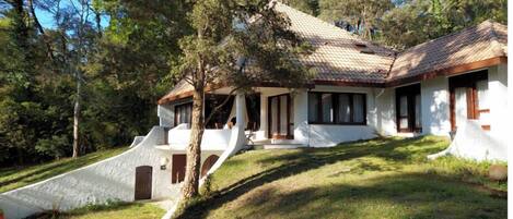 A house with a sloped roof, a porch, and a small staircase leading to the entrance.