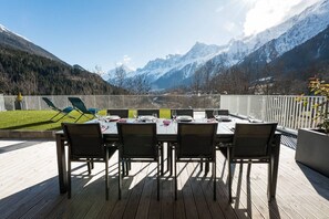 Een terras met een uitzicht op besneeuwde bergen.