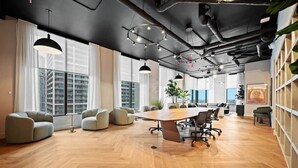 Una sala de conferencias moderna con una gran mesa, asientos cómodos y ventanas amplias con vista a la ciudad.