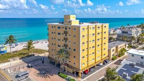 A multi-story hotel with balconies, located near a beach with clear blue water. - Oceanfront 2BR/2BA · Pool, Free Parking + Views (Hollywood)