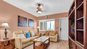 A living room with a sofa, coffee table, lamp, and artwork on the wall. - Oceanfront 2BR/2BA · Pool, Free Parking + Views (Hollywood)