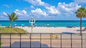 A beach with a clear sky, palm trees, and umbrellas. - Oceanfront 2BR/2BA · Pool, Free Parking + Views (Hollywood)