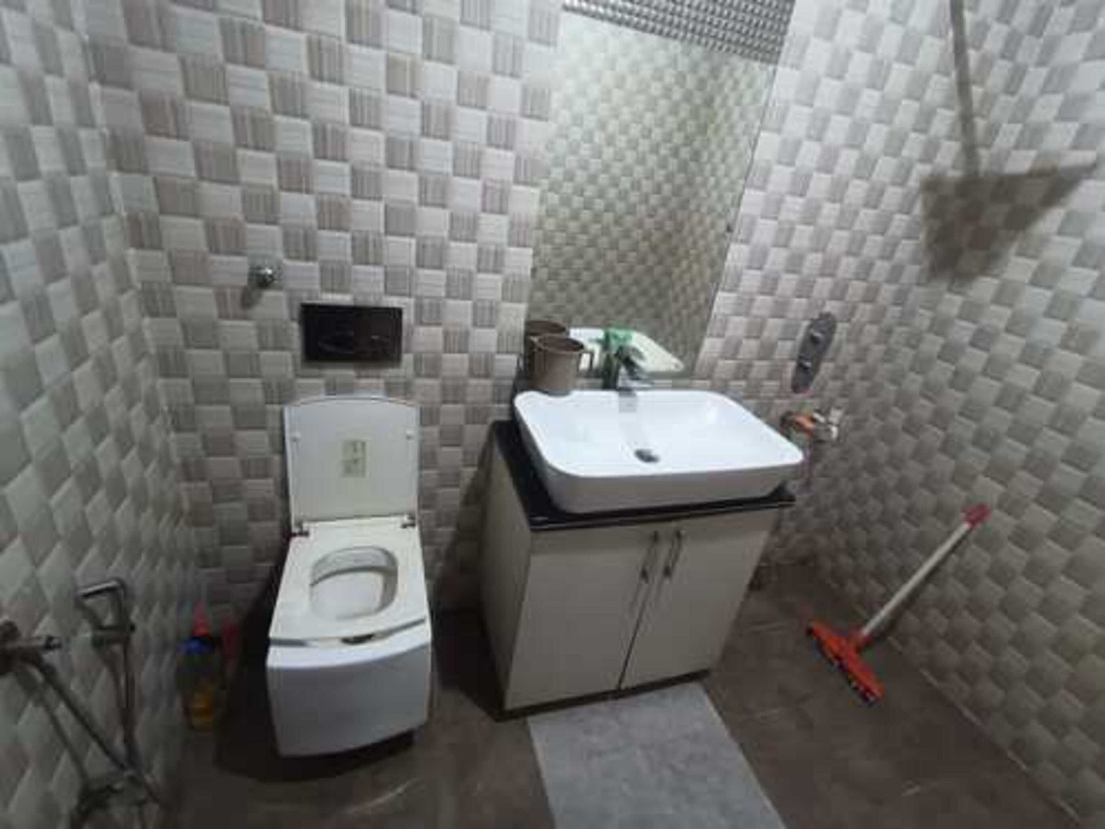 Une petite salle de bain comprenant des toilettes, un lavabo et un espace douche.