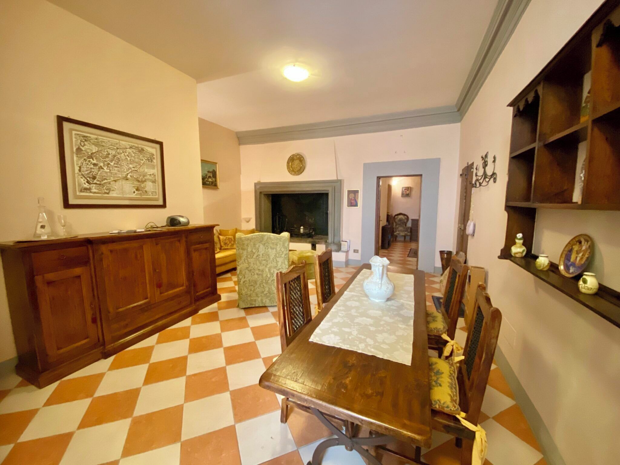 Un comedor con suelo a cuadros, muebles de madera y una chimenea.