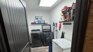 A laundry room with a washing machine, dryer, and a small window. - Relax comfortably & enjoy a 2-bedroom studio in Valdez perfect for your getaway. (Valdez)
