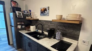 A modern kitchen with a double sink, a built-in stove, and a refrigerator. - Relax comfortably & enjoy a 2-bedroom studio in Valdez perfect for your getaway. (Valdez)