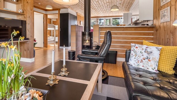 A modern interior with a fireplace, leather seating, and wooden accents. - "Eivi" - 200m from the sea by Interhome (Væggerløse)