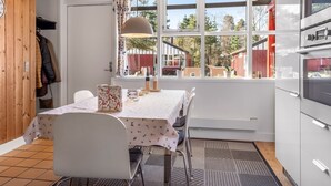 A kitchen with a dining area, wooden ceiling, large windows, and a view of the outside. - "Eivi" - 200m from the sea by Interhome (Væggerløse)