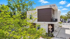 Un bâtiment moderne doté d’un toit plat, d’un balcon et d’une enseigne indiquant « KaSa ».