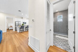 A modern kitchen with white cabinets and a dining area with two chairs. - Bright & Modern 3BR Home – Prime Tampa Location (Tampa)