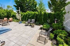 A patio with outdoor furniture, a flag, and lush greenery. - Downtown Bristol Studio Near Ferry & Waterfront (Bristol)