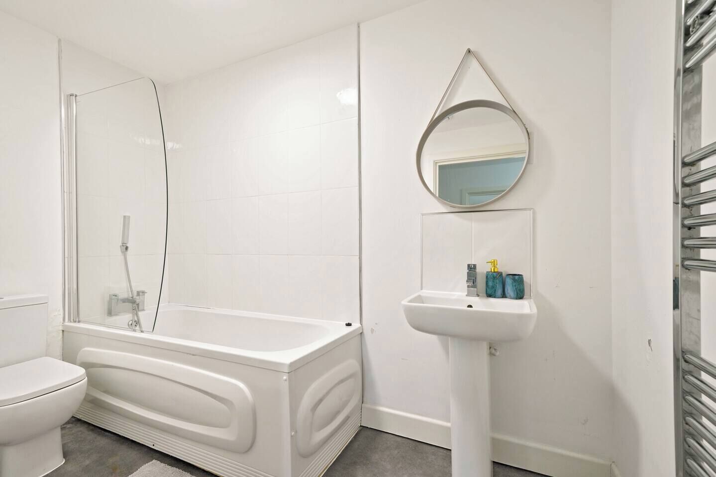 A bathroom with a bathtub, toilet, and a sink with a mirror above it.