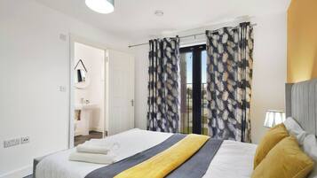 Una camera d'albergo con un letto, un comodino, una lampada e vista all'esterno.