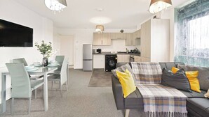 Um apartamento moderno com área de refeições, cozinha e sala de estar.