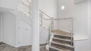 A modern interior with a staircase, white walls, and a carpeted floor. - Stylish 1BR Near Heathrow & Elizabeth Line 8 (London)
